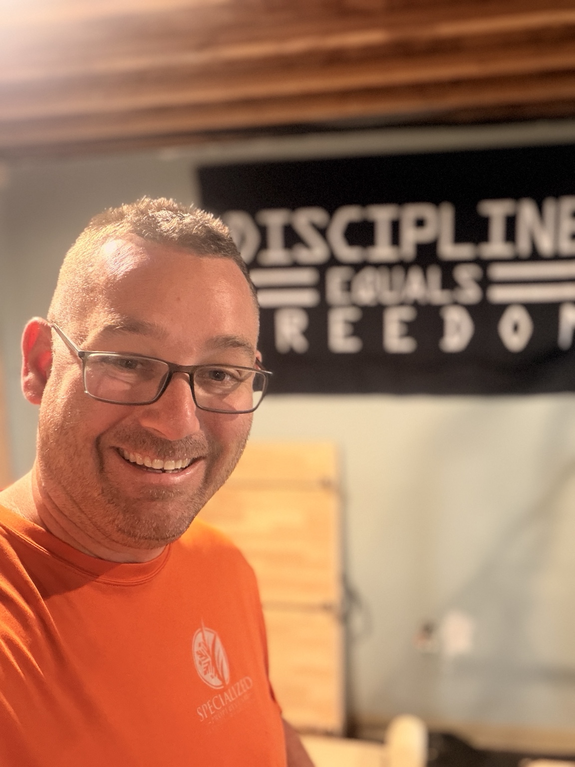 Charles Haddock smiling in an orange shirt
